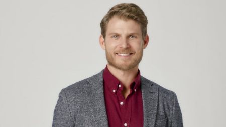 Travis Van Winkle in a grey suit poses for a picture.